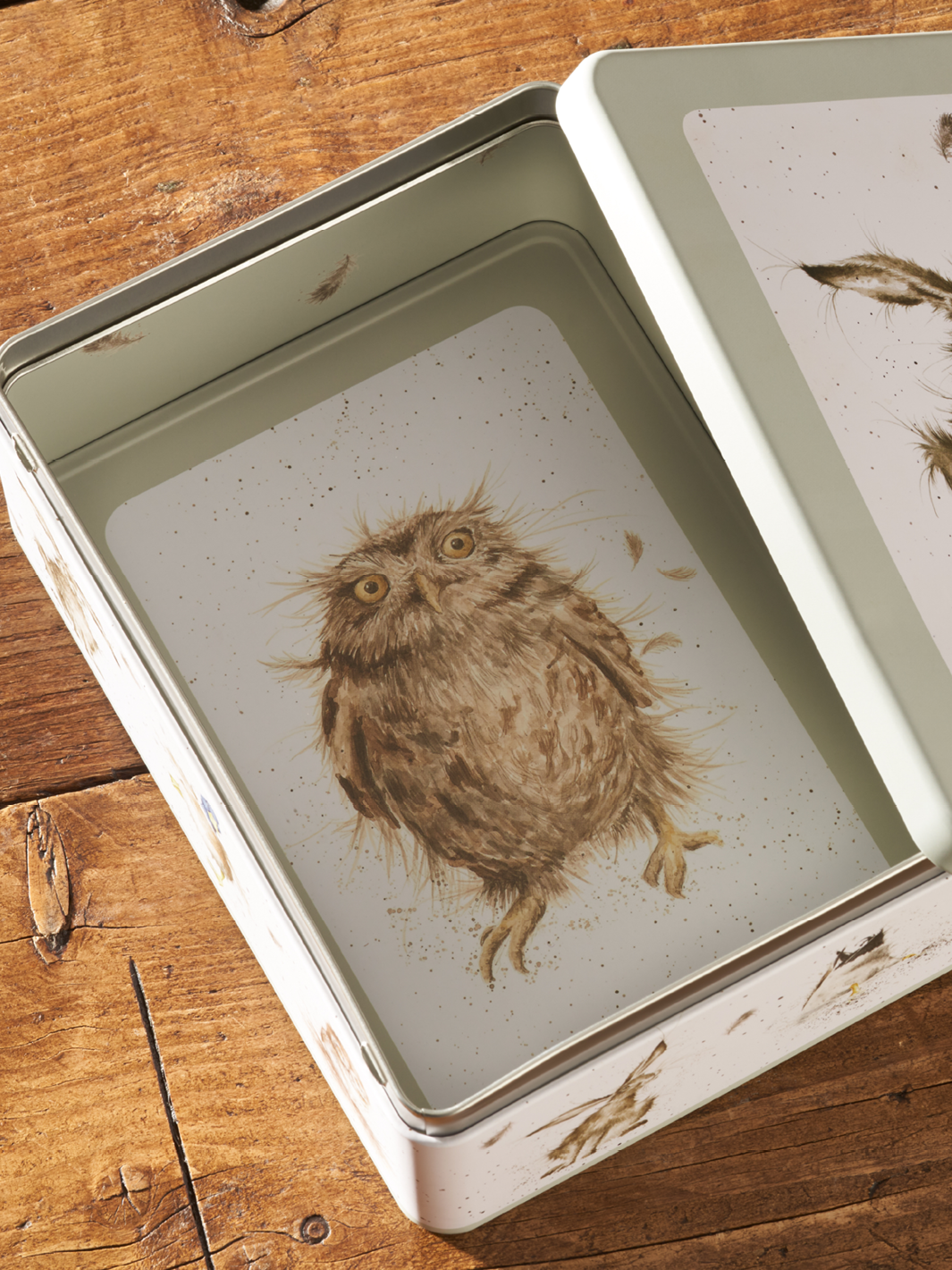Tin packaging with an internal print of a cartoon owl.