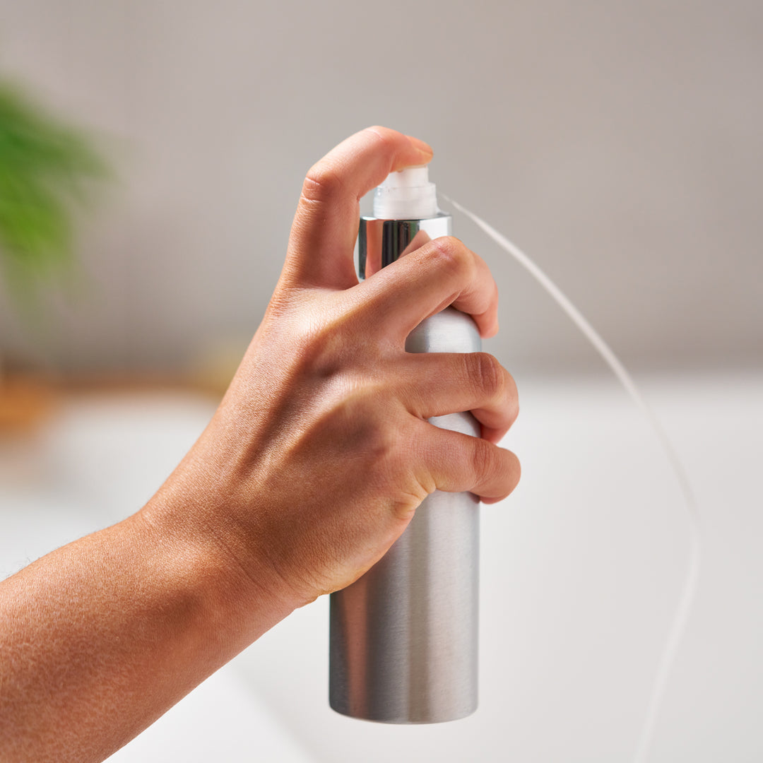 The optional pump cap being used to express liquid from the aluminium bottle.
